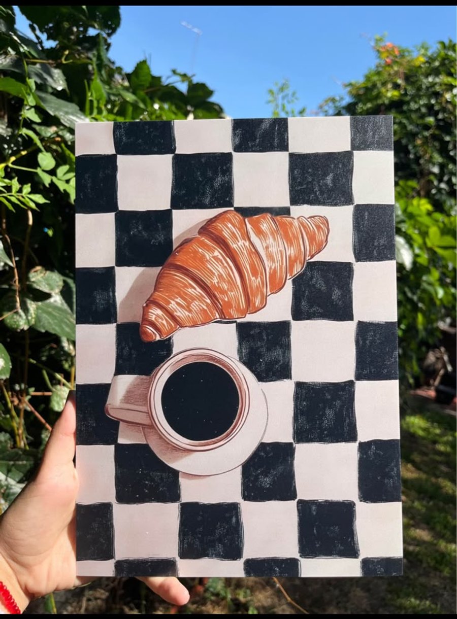 Cuadro con una ilustración de croissant y café, en la mano al aire libre