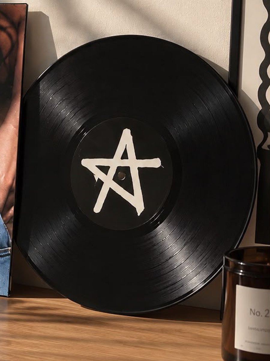 Cuadro de vinilo con una estrella, apoyado en un escritorio